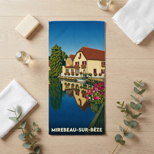 Serviette de bain souvenir de Mirebeau-sur-Bèze illustrée d'un paysage pittoresque au bord de l'eau.