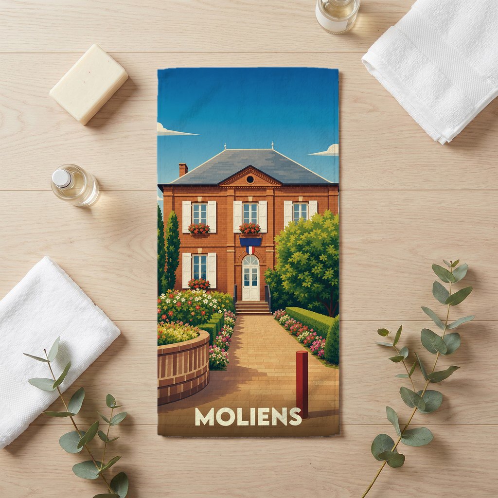 Serviette de bain souvenir de la ville de Moliens illustrée d'une bâtisse traditionnelle en briques sous un ciel bleu.