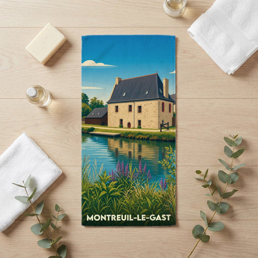 Serviette de bain souvenir de Montreuil-le-Gast avec une illustration stylisée d'une maison au bord de l'eau.