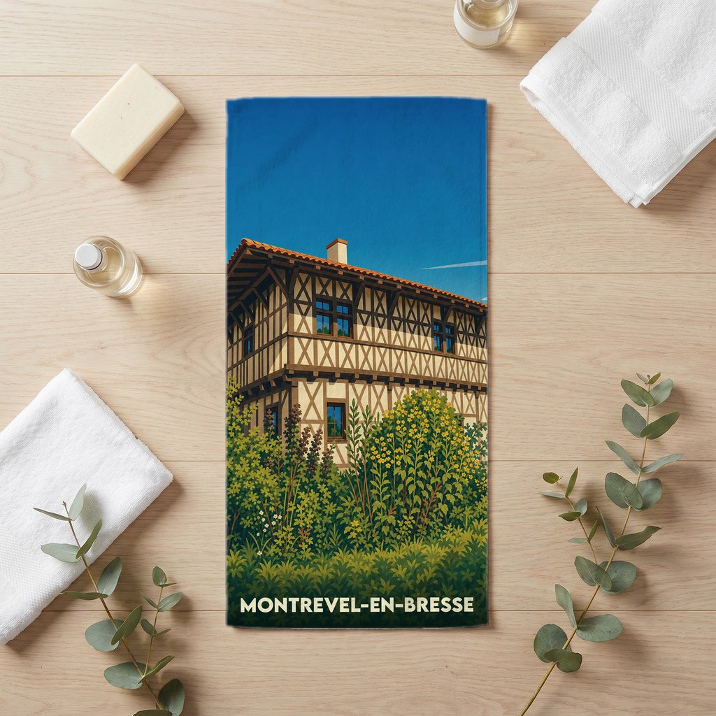 Serviette de bain souvenir de Montrevel-en-Bresse avec une illustration stylisée d'une maison à colombages.
