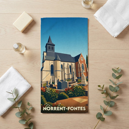 Serviette de bain souvenir de la ville de Norrent-Fontes avec une illustration stylisée d'une église et son cimetière.