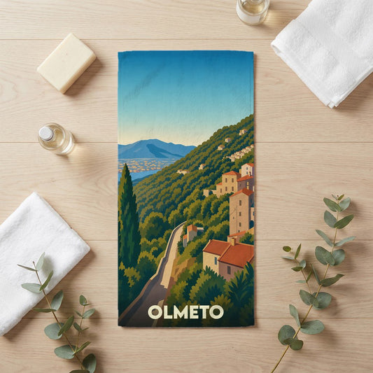 Serviette de bain souvenir de la ville d'Olmeto avec une illustration stylisée de paysages corses.