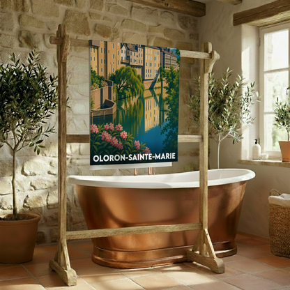 Serviette de bain souvenir de la ville d'Oloron-Sainte-Marie avec une illustration stylisée de ses bâtiments se reflétant dans l'eau.