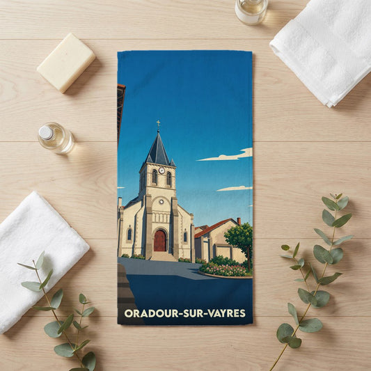 Serviette de bain souvenir de la ville d'Oradour-sur-Vayres illustrant son église sous un ciel bleu.