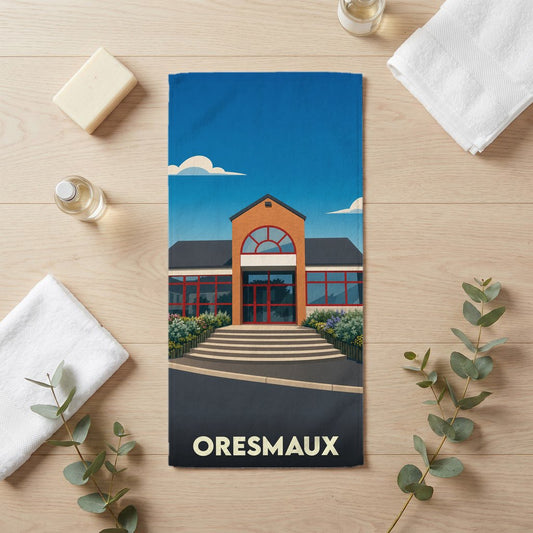 Serviette de bain souvenir de la ville d'Oresmaux avec une illustration stylisée de sa mairie.