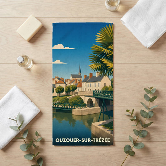 Serviette de bain souvenir de la ville de Ouzouer-sur-Trézée avec une illustration stylisée d'un paysage urbain au bord de l'eau.