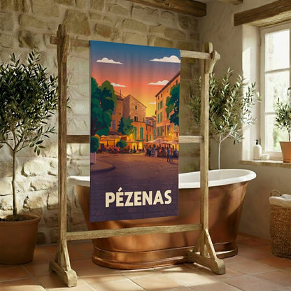 Serviette de bain souvenir de la ville de Pézenas avec une illustration stylisée d'une place au coucher du soleil.