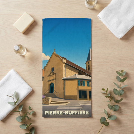 Serviette de bain souvenir de la ville de Pierre-Buffière avec une illustration stylisée de son église.