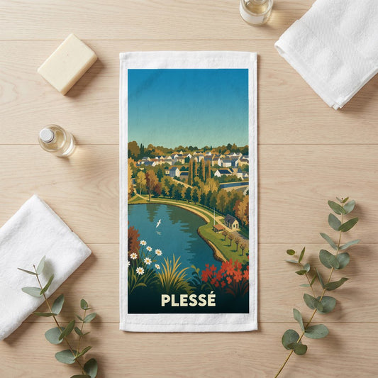 Serviette de bain souvenir de la ville de Plessé avec une illustration stylisée d'un paysage lacustre.