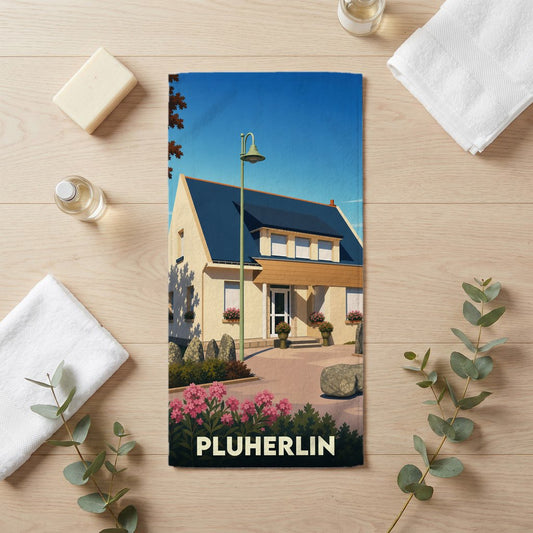 Serviette de bain souvenir de la ville de Pluherlin avec une illustration stylisée d'une maison bretonne.