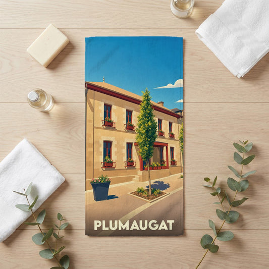 Serviette de bain souvenir de la ville de Plumaugat avec une illustration stylisée d'un bâtiment fleuri.