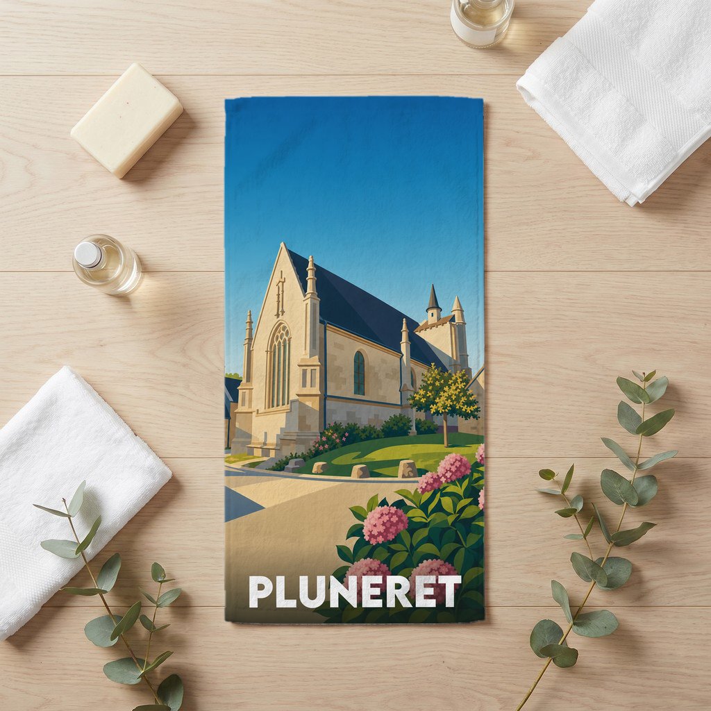 Serviette de bain souvenir de la ville de Pluneret illustrée d'une église sous un ciel bleu.