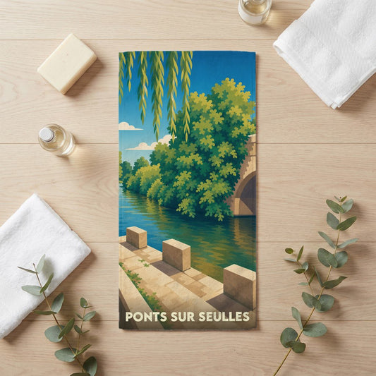 Serviette de bain souvenir de la ville de Ponts sur Seulles avec une illustration stylisée d'un pont en bord de rivière.