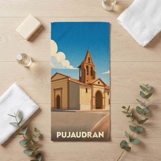 Serviette de bain souvenir de la ville de Pujaudran avec une illustration stylisée d'église sous un ciel bleu.