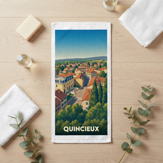 Serviette de bain souvenir de la ville de Quincieux avec une illustration paysagère stylisée.
