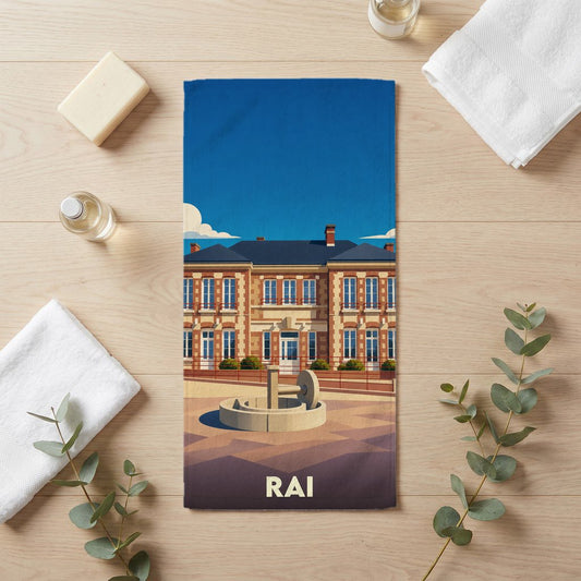 Serviette de bain souvenir de la ville de Rai avec une illustration stylisée d'un bâtiment historique et de sa fontaine.