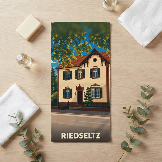 Serviette de bain souvenir de la ville de Riedseltz avec l'illustration d'une maison traditionnelle alsacienne.
