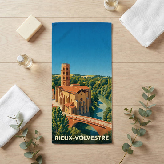 Serviette de bain souvenir de Rieux-Volvestre illustrée d'une vue stylisée sur la cathédrale, le pont et la rivière.