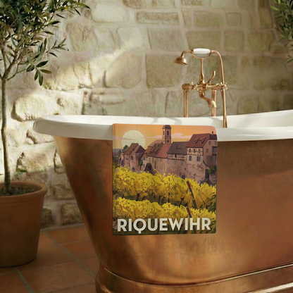 Serviette de bain souvenir de la ville de Riquewihr avec une illustration stylisée de ses vignobles et de ses maisons traditionnelles.