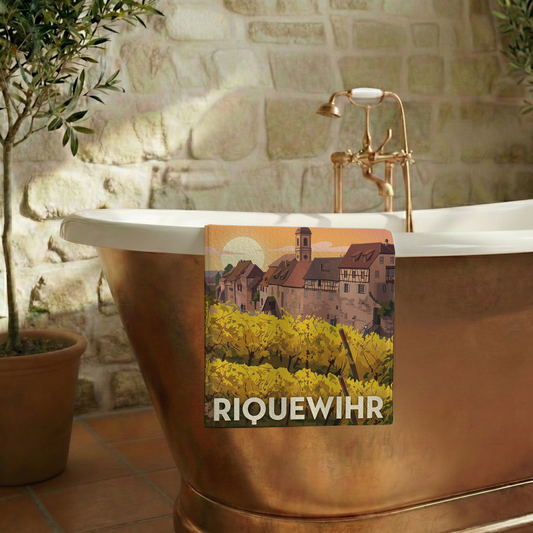 Serviette de bain souvenir de la ville de Riquewihr avec une illustration stylisée de ses vignobles et de ses maisons traditionnelles.