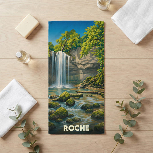 Serviette de bain souvenir de la ville de Roche illustrée d'une cascade dans un décor naturel verdoyant.