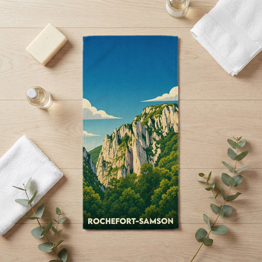 Serviette de bain souvenir de la ville de Rochefort-Samson avec une illustration stylisée d'un paysage montagneux.