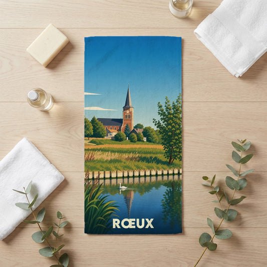 Serviette de bain souvenir de la ville de Rœux avec une illustration stylisée d'une église au bord de l'eau.