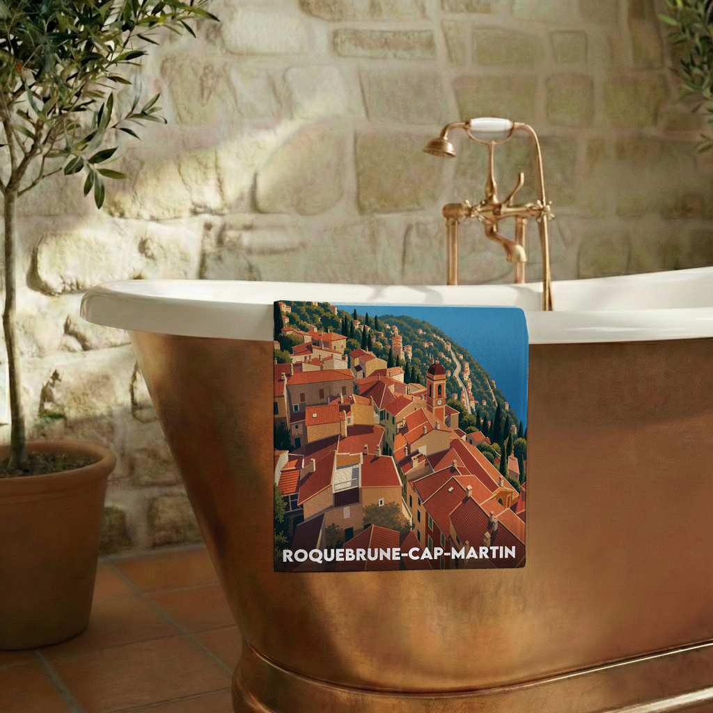 Serviette de bain souvenir de Roquebrune-Cap-Martin avec une illustration stylisée du village perché.