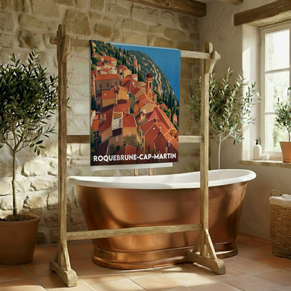 Serviette de bain souvenir de la ville de Roquebrune-Cap-Martin avec une illustration stylisée d'un village côtier.