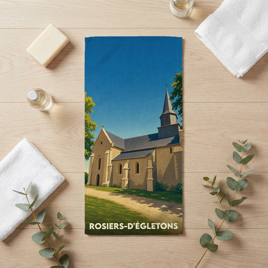 Serviette de bain souvenir de Rosiers-d'Égletons avec une illustration stylisée de son église sous un ciel bleu.