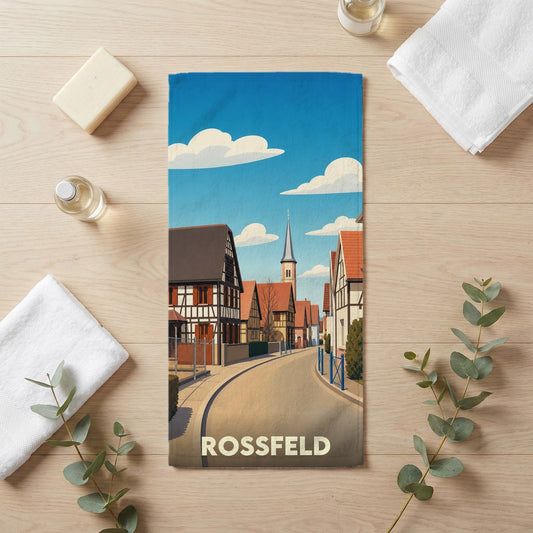 Serviette de bain souvenir de la ville de Rossfeld avec une illustration stylisée de maisons à colombages et d'un clocher.