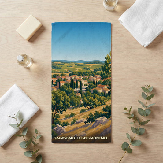 Serviette de bain souvenir de Saint-Bauzille-de-Montmel avec une illustration de paysage de village.