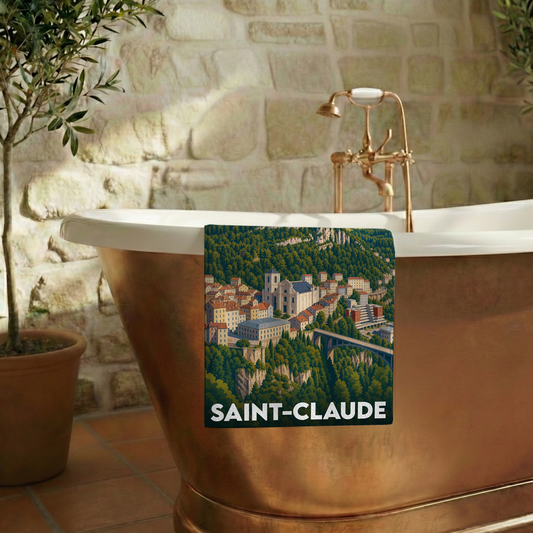 Serviette de bain souvenir de la ville de Saint-Claude avec une illustration stylisée de son paysage urbain et montagneux.