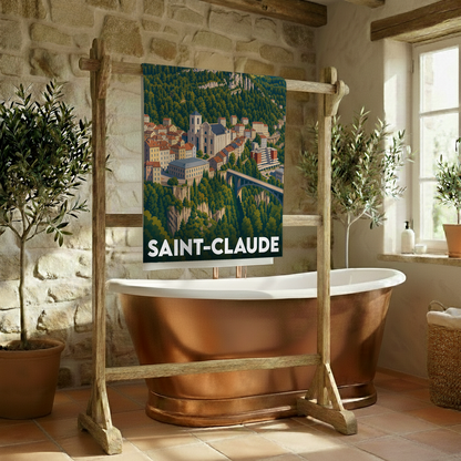 Serviette de bain souvenir de la ville de Saint-Claude avec une illustration stylisée d'un paysage montagneux et urbain.