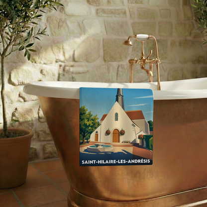 Serviette de bain souvenir de Saint-Hilaire-les-Andrésis avec une illustration stylisée de la ville.
