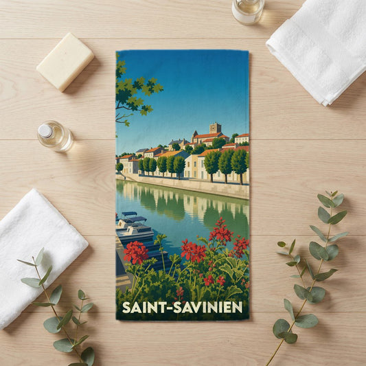 Serviette de bain souvenir de Saint-Savinien illustrée par une vue pittoresque de la ville au bord de l'eau.