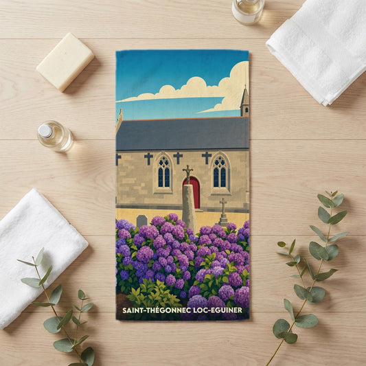 Serviette de bain souvenir de Saint-Thégonnec Loc-Eguiner avec une illustration stylisée de son église et de fleurs violettes.