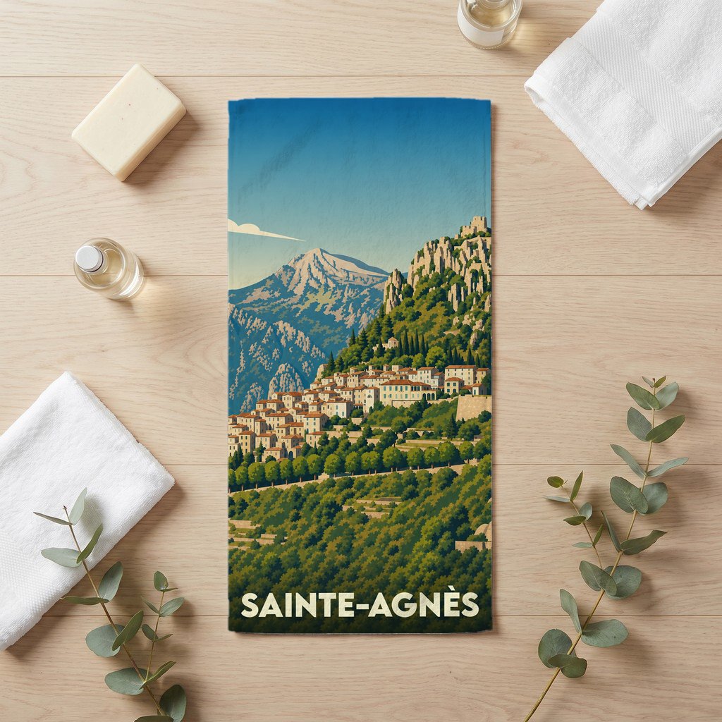 Serviette de bain souvenir de la ville de Sainte-Agnès avec une illustration stylisée de montagne.