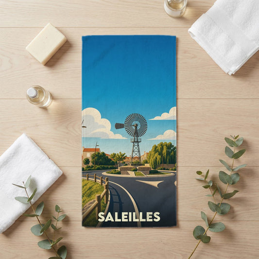 Serviette de bain souvenir de la ville de Saleilles avec une illustration stylisée représentant un moulin à vent sur un rond-point.