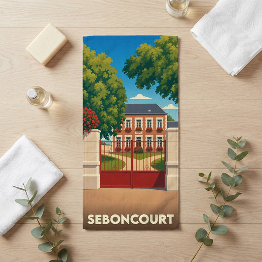 Serviette de bain souvenir de la ville de Seboncourt avec une illustration stylisée d'un manoir derrière une grille rouge.