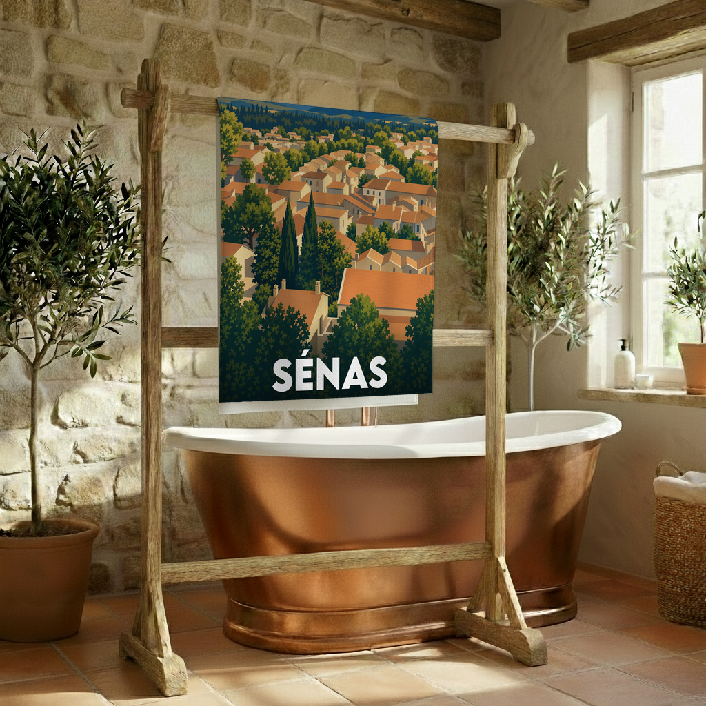 Serviette de bain souvenir de la ville de Sénas avec une illustration stylisée d'un village provençal.