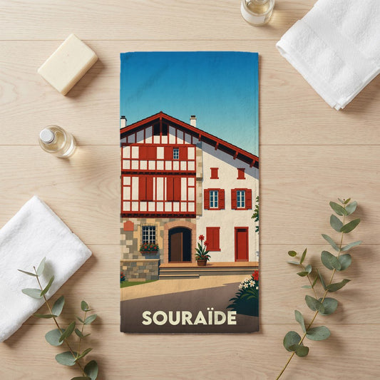 Serviette de bain souvenir de la ville de Souraïde illustrant une maison basque traditionnelle.