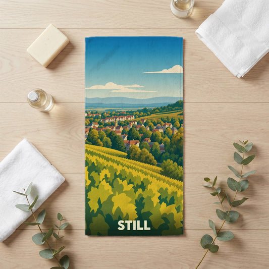 Serviette de bain souvenir de la ville de Still avec une illustration stylisée de son paysage vallonné.