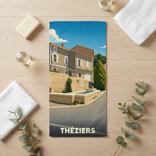 Serviette de bain souvenir de la ville de Théziers avec une illustration stylisée.
