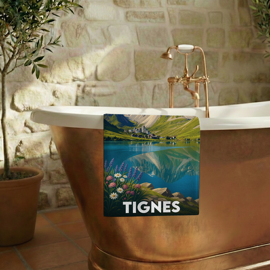 Serviette de bain souvenir de la ville de Tignes avec une illustration stylisée d'un paysage de montagne et de lac.