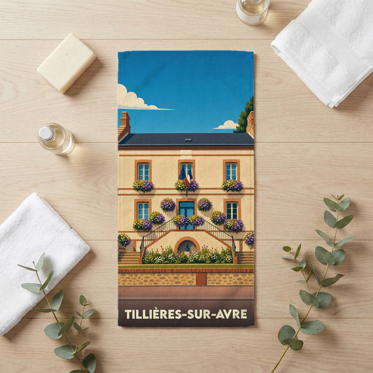 Serviette de bain souvenir de Tillières-sur-Avre illustrant l'hôtel de ville fleuri sous un ciel bleu.