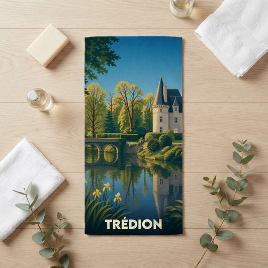 Serviette de bain souvenir de la ville de Trédion avec une illustration stylisée d'un château au bord de l'eau.