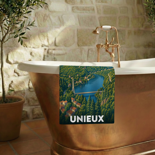 Serviette de bain souvenir de la ville d'Unieux illustrée d'un paysage de rivière et de forêt.
