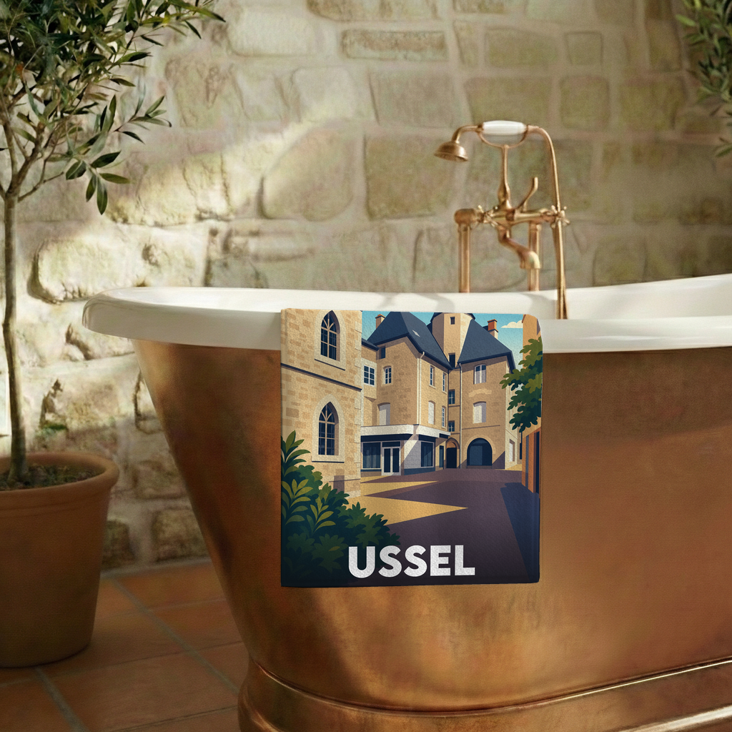 Serviette de bain souvenir de la ville d'Ussel avec une illustration stylisée de ses bâtiments historiques.