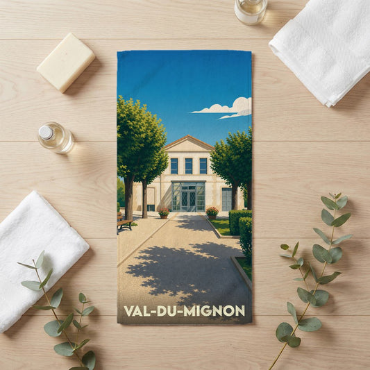 Serviette de bain souvenir de Val-du-Mignon avec une illustration stylisée d'un bâtiment ensoleillé.